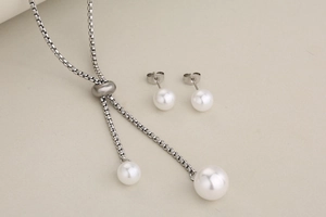 Detail of adjustable Y-shaped stainless steel necklace and round pearl stud earrings set