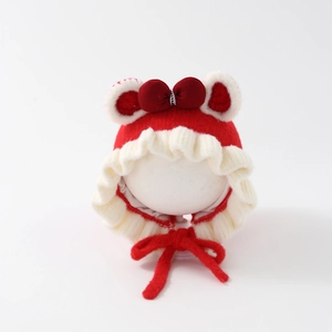 Detailed view of baby winter hat featuring plush ears, red bow and chin strap ties