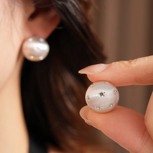 Gros plan détaillé d'une boucle d'oreille en argent brossé avec étoiles en cristal