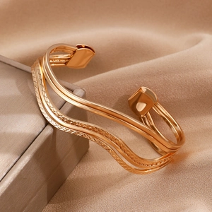 Elegante goudkleurige golfvormige open manchetarmband met diagonale textuurpatronen