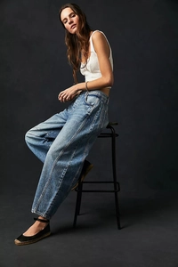 Détail du jean denim bleu à jambes larges montrant coutures et texture délavée