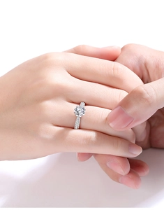 Detailed view of an s925 silver engagement ring with one carat round moissanite on a finger