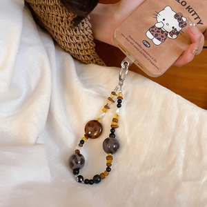 Detailed shot of leopard and amber acrylic beaded phone strap with silver ring buckle