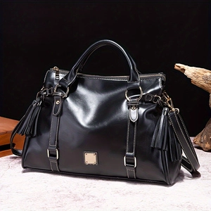 Bolso de mano retro de cuero negro con borlas y detalles dorados en mármol