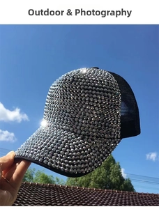 Detailed view of shiny silver rhinestones on a black breathable mesh baseball cap