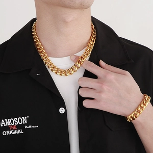 Close-up of a model wearing a gold Cuban link chain necklace and matching bracelet set