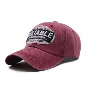 Close-up of vintage washed burgundy baseball cap with reliable embroidery and metal buckle