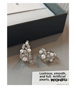 Macro shot of silver hollow basket earrings with inlaid pearls and shimmering crystals