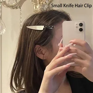 Creative knife-shaped hair clip with silver blade and black handle worn on side hair