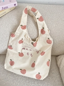 Minimalist canvas tote bag with peach print and sweet taste of peaches text on a sofa