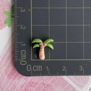 Miniature de cocotier en résine montrant une taille de 1,5 cm sur un tapis de découpe noir