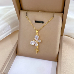 Close-up of gold butterfly necklace with zircon crystals and cross pendant in jewelry box
