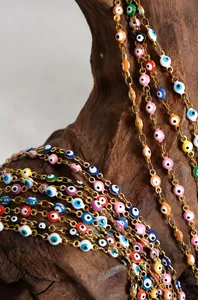 Detailed shot of multi-color evil eye enamel charms on a vintage 18k gold plated chain