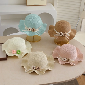 Detailed view of woven straw sun hats with floral lace ribbons in five vibrant colors