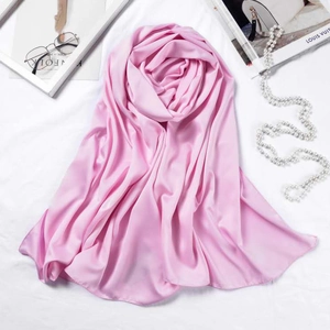 Detailed texture of pink silk scarf with pearls and fashion magazines background