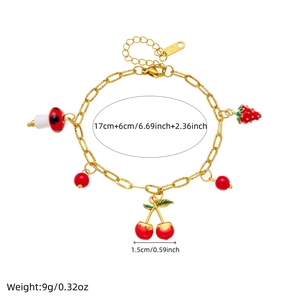Bracelet doré à la mode avec breloques fraise, cerise et champignon sur fond blanc