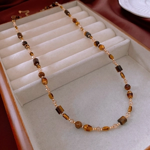 Detail of vintage beaded necklace with tiger-eye texture beads and gold spacer beads