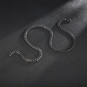 Macro detail of gunmetal curb chain with polished flat links on textured background