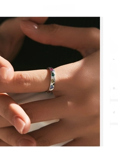 Detail shot of silver ring with colorful heart-shaped stones worn on a model's hand