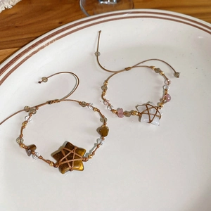 Detailed view of handmade woven bracelets with star-shaped tiger eye stone and crystals
