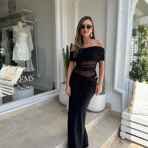 Detail of elegant black off-shoulder dress with sheer mesh waist and slim silhouette