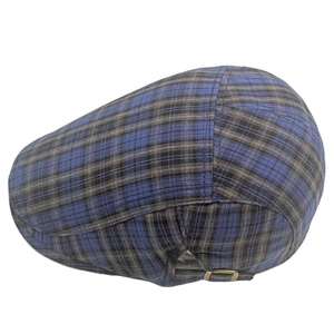 Détail d'une casquette gavroche à carreaux avec boucle réglable en bronze et coutures fines