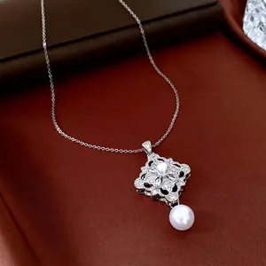 Elegant silver pearl necklace with floral zircon pendant on a premium leather surface