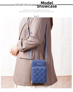 Detailed side view of quilted navy crossbody bag with multi-zipper layers and strap