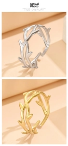 Detailed view of nature-inspired branch rings in gold and silver polished stainless steel