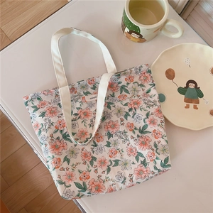 Close-up of floral cotton tote bag featuring pink flower patterns and a simple patch