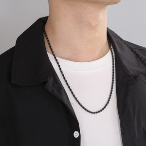 Close-up of a black metal rope chain necklace shown on a male model neckline