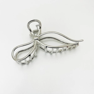 Close-up of minimalist silver butterfly metal hair claw clip with a polished finish