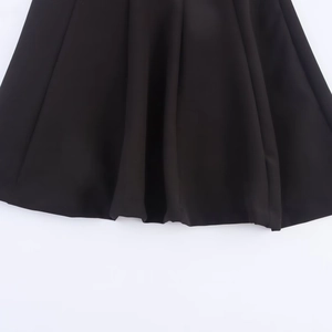 Short black dress with contrast bow and wavy hemline detail in 2025 autumn style