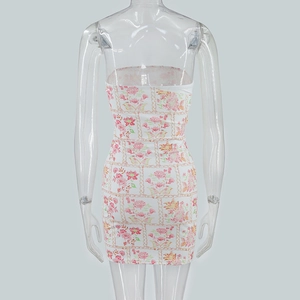 Detail of white tube dress featuring pink floral and gold chain prints on slim fit fabric
