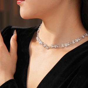 Close-up of geometric silver chain necklace with zircon inlay worn by a model