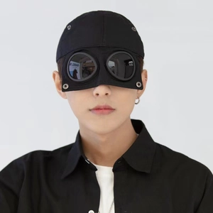 Close-up of integrated goggles on a black pilot style baseball cap with lens detail