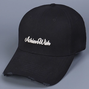 Detailed close-up of white Achieve Wish letter embroidery on a black distressed baseball cap