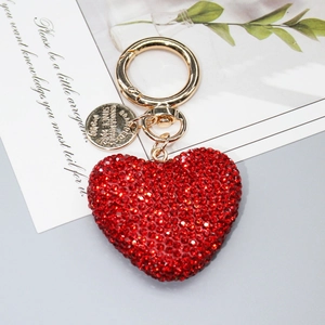 Dettaglio portachiavi a cuore con strass rossi brillanti e anello in metallo dorato