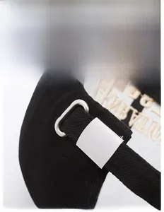 Detail of adjustable metal buckle and twill cotton fabric on black baseball cap