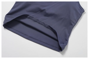 Close-up of contrast white binding and double-stitch hem on navy yoga tank top