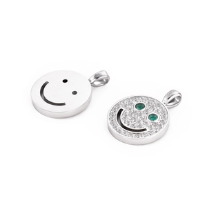 Detail of silver smiley pendant and white zircon pavé charm with green eyes