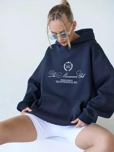 Detail of The Movement Club white letter print on navy blue oversized cotton hoodie