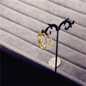 Detail of oversized gold crystal hoop earrings adorned with sparkling rhinestones