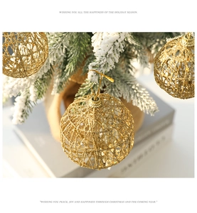Detail of golden glitter iron mesh Christmas ball ornament hanging on a snowy pine branch