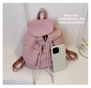 Detailed size comparison of a pink nylon backpack with a smartphone in a lifestyle setting