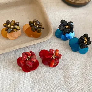 Three pairs of vintage floral stud earrings featuring tiger eye stone and resin petals