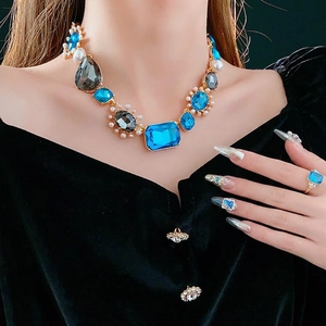 Vintage luxury statement necklace with blue crystals and pearls on model with black velvet