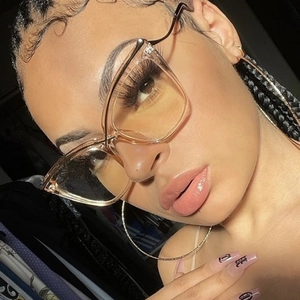 Close-up of champagne cat-eye glasses on a model showing the oversized frame fit
