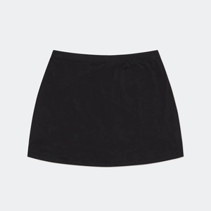 Detail of the elastic waistband and stitching on a black mini skirt with cross patterns