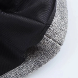 Detail of grey and black patchwork tweed hat with soft inner lining texture
